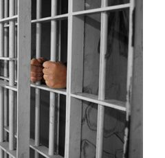 Man's hand in jail bars in Louisiana - Troy's Bail Bonds